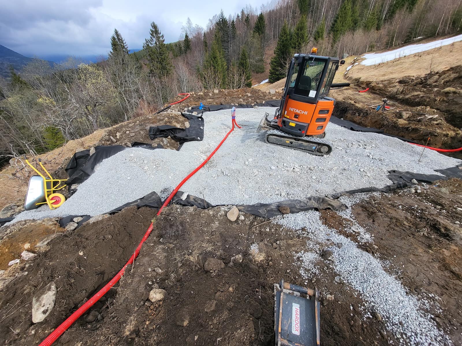 Minigraver på oppbygd grusflate i skrånende terreng, Seljord
